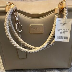 Bebe classic tabletop purse with arm straps.